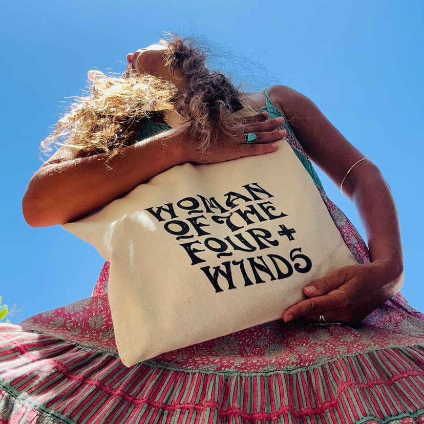 woman holding a bag that reads woman of the four winds